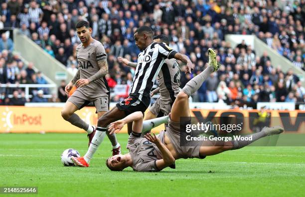 Alexander Isak of Newcastle United scores his team's first goal as Micky van de Ven of Tottenham Hotspur falls during the Premier League match...