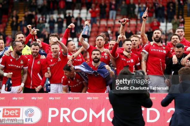 Players of Wrexham celebrate victory and promotion into League One following the Sky Bet League Two match between Wrexham and Forest Green Rovers at...