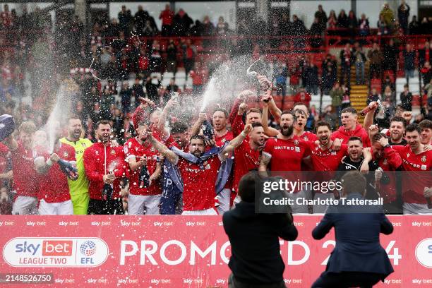 Players of Wrexham celebrate victory and promotion into League One following the Sky Bet League Two match between Wrexham and Forest Green Rovers at...