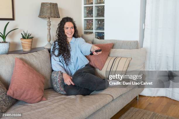 woman watching television in living room - zapping stock pictures, royalty-free photos & images