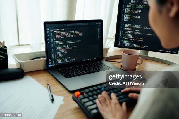 woman programmer engaged in coding at desk - webdesigner stockfoto's en -beelden