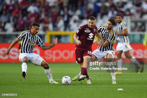 Nikola Vlasic of Torino FC passes the ball under pressure from Manuel Locatelli and Danilo of Juventus during the Serie A TIM match between Torino FC...