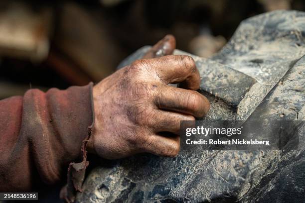 Mechanic's hand rests on the rear wheel of a 1984 Case tractor April 5, 2024 at the LaBerge Brothers Farm in Charlotte, Vermont.