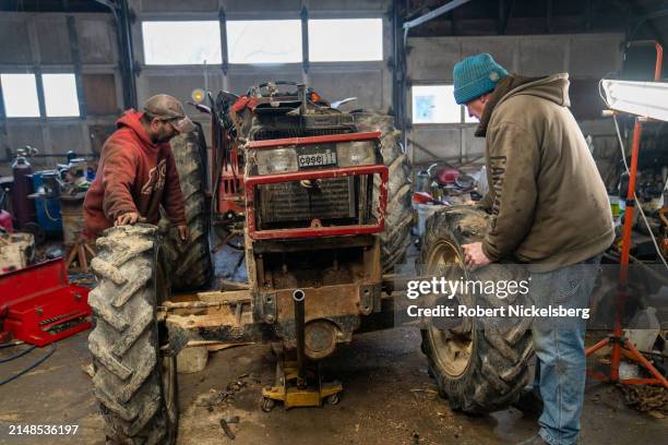 Mechanic, left, and Amie LaBerge, right, separate the front engine and wheels from the rear chassis of a 1984 Case tractor April 5, 2024 at the...