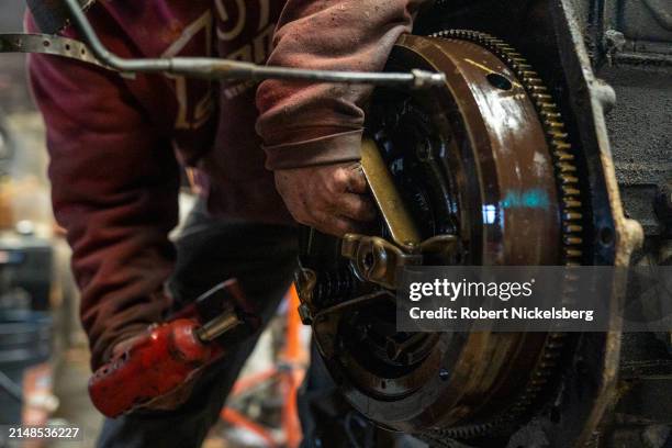 Mechanic, left, removes the clutch assembly of a 1984 Case tractor April 5, 2024 at the LaBerge Brothers Farm in Charlotte, Vermont.