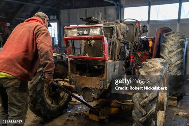 Mechanic raises the chassis of a 1984 Case farm tractor April 5, 2024 at the LaBerge Brothers Farm in Charlotte, Vermont.