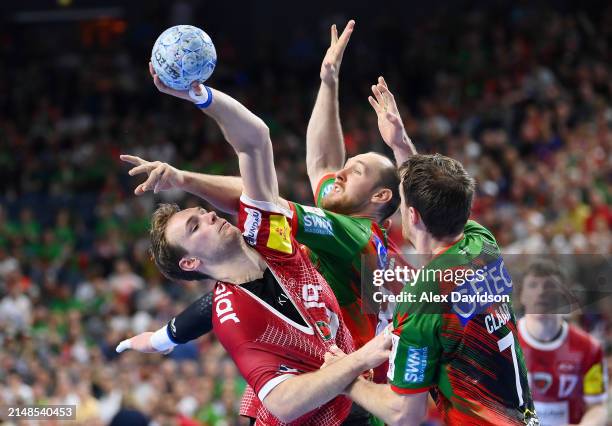 Mathias Gidsel of Füchse Berlin is takled by Christian O'Sullivan and Felix Claar of SC Magdeburg during the REWE Final4 match between SC Magdeburg...