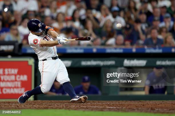 Jose Altuve of the Houston Astros hits a RBI double in the seventh inning against the Texas Rangers at Minute Maid Park on April 13, 2024 in Houston,...