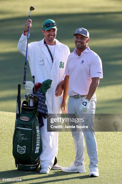 Bryson DeChambeau of the United States and caddie Greg Bodine celebrate after chipping in for birdie on the 18th green during the third round of the...