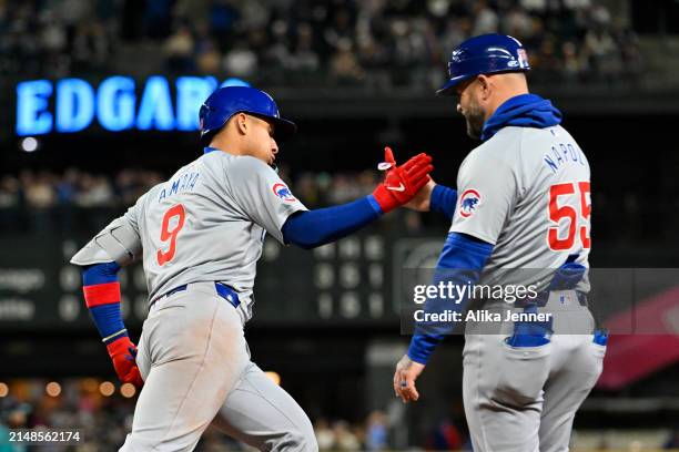 Miguel Amaya of the Chicago Cubs shakes hands with first base coach Mike Napoli after hitting a solo home run during the eighth inning against the...