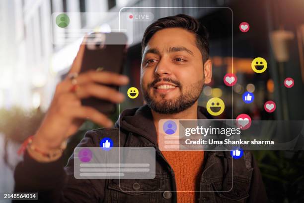 social media: a male influencer is seen smiling while doing a live-streaming vlog on social media. - social media marketing foto e immagini stock