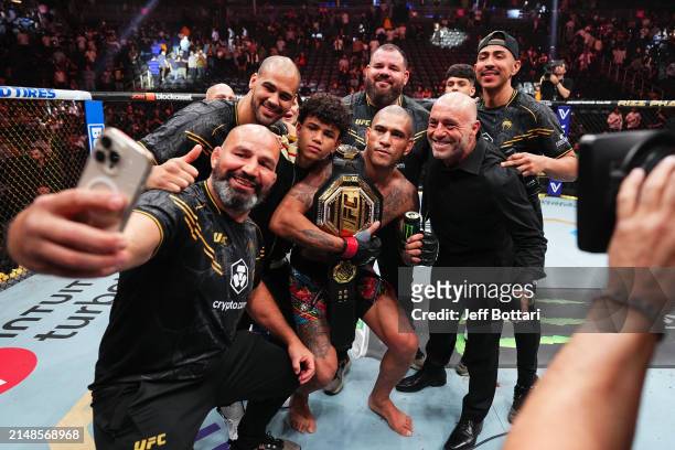 Alex Pereira of Brazil, Joe Rogan and his team pose for a photo in the Octagon in the UFC light heavyweight championship fight during the UFC 300...