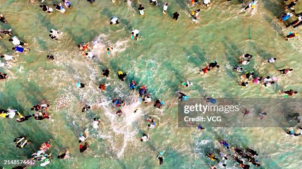 Aerial view of tourists and local people celebrating the water-splashing festival on April 13, 2024 in Yuanyang County, Honghe Hani and Yi Autonomous...