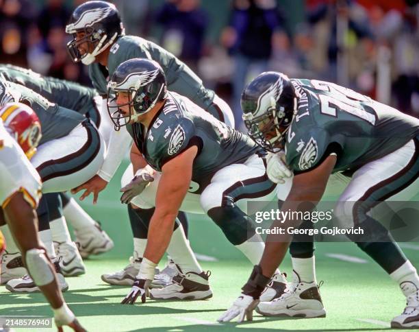 Guard John Welbourn and tackle Tra Thomas of the Philadelphia Eagles look on from the line of scrimmage as quarterback Donovan McNabb stands behind...