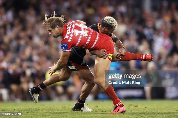 Jack De Belin of the Dragons is tackled by Apisai Koroisau of the Tigers during the round six NRL match between Wests Tigers and St George Illawarra...