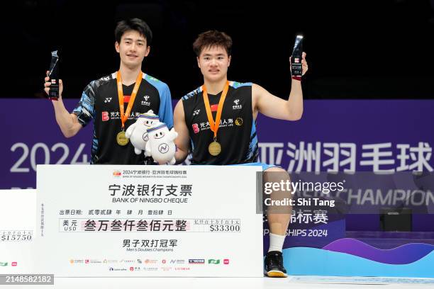 Liang Weikeng and Wang Chang of China pose with their trophies on the podium after the Men's Doubles Final match against Goh Sze Fei and Nur Izzuddin...