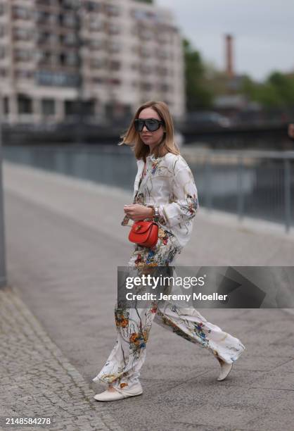 Sonia Lyson seen wearing Tom Ford black sunglasses with blue transparent lenses, Munthe white linen with colorful flower print pattern buttoned...