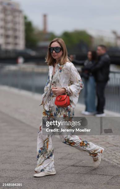 Sonia Lyson seen wearing Tom Ford black sunglasses with blue transparent lenses, Munthe white linen with colorful flower print pattern buttoned...