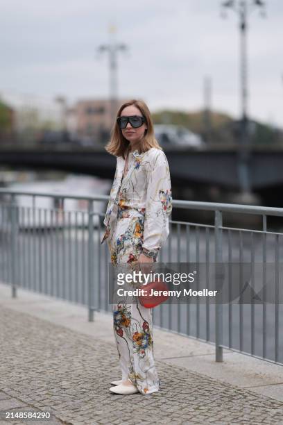 Sonia Lyson seen wearing Tom Ford black sunglasses with blue transparent lenses, Munthe white linen with colorful flower print pattern buttoned...