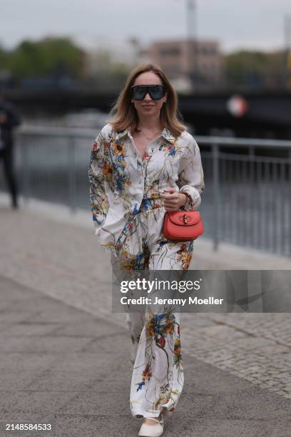 Sonia Lyson seen wearing Tom Ford black sunglasses with blue transparent lenses, Munthe white linen with colorful flower print pattern buttoned...