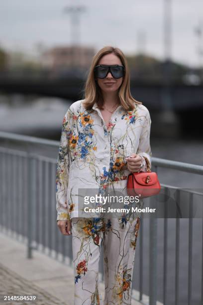 Sonia Lyson seen wearing Tom Ford black sunglasses with blue transparent lenses, Munthe white linen with colorful flower print pattern buttoned...