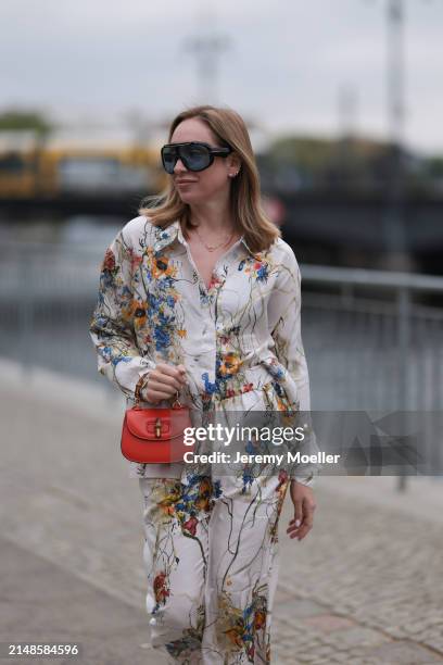 Sonia Lyson seen wearing Tom Ford black sunglasses with blue transparent lenses, Munthe white linen with colorful flower print pattern buttoned...