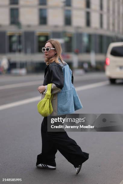 Sonia Lyson seen wearing Christian Dior white sunglasses, Munthe black leather / beige / blue denim patchwork jacket, Zara black wide leg pants,...