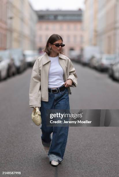 Sophia Geiss seen wearing Saint Lauren black sunglasses, Uniqlo white cotton basic top, Calvin Klein blue denim baggy jeans pants, black leather...