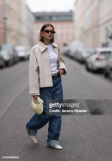 Sophia Geiss seen wearing Saint Lauren black sunglasses, Uniqlo white cotton basic top, Calvin Klein blue denim baggy jeans pants, black leather...