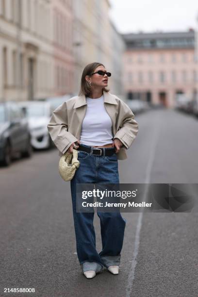 Sophia Geiss seen wearing Saint Lauren black sunglasses, Uniqlo white cotton basic top, Calvin Klein blue denim baggy jeans pants, black leather...