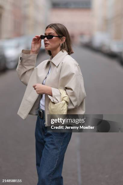 Sophia Geiss seen wearing Saint Lauren black sunglasses, Uniqlo white cotton basic top, Calvin Klein blue denim baggy wide leg jeans pants, black...