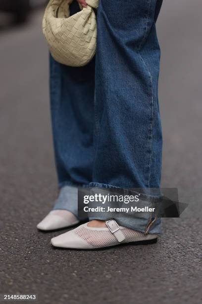 Sophia Geiss seen wearing Calvin Klein blue denim baggy wide leg jeans pants, Bottega Veneta creamy white / vanilla leather mini Jodie bag and...