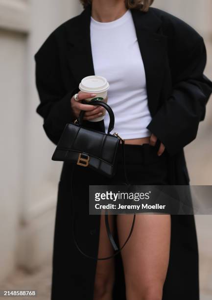 Sophia Geiss seen wearing Uniqlo white cotton basic top, Mango mini / micro shorts, 032c black long blazer coat and Balenciaga black leather...