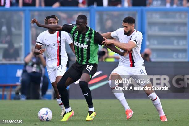Pedro Obiang of US Sassuolo is challenged by Ruben Loftus-Cheek and Samuel Chukwueze of AC Milan during the Serie A TIM match between US Sassuolo and...