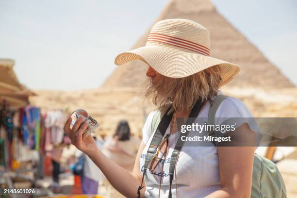 woman looking for souvenirs in cairo. pyramid figures for gift.young female tourist at the street market of giza. - giza stock pictures, royalty-free photos & images