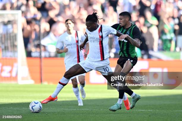 Rafael Leao of AC Milan runs with the ball whilst under pressure from Ruan Tressoldi of US Sassuolo during the Serie A TIM match between US Sassuolo...