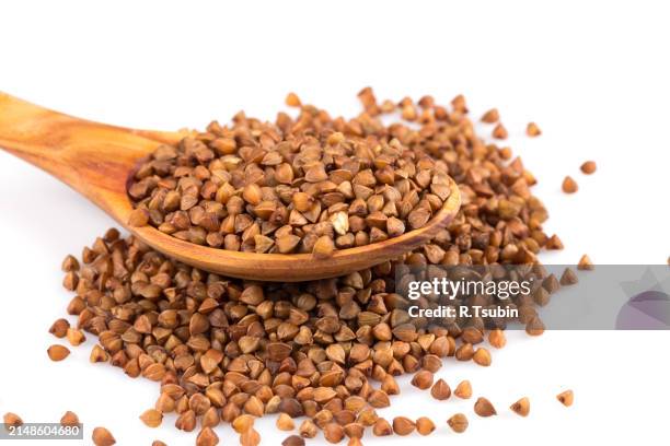 uncooked buckwheat on wooden spoon - unprocessed stock pictures, royalty-free photos & images