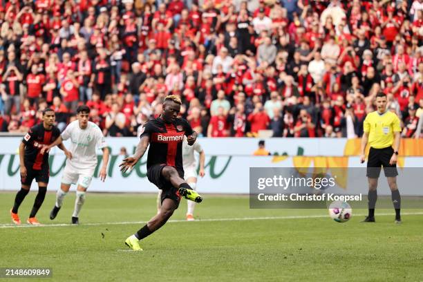 Victor Boniface of Bayer Leverkusen scores his team's first goal from the penalty spot during the Bundesliga match between Bayer 04 Leverkusen and SV...