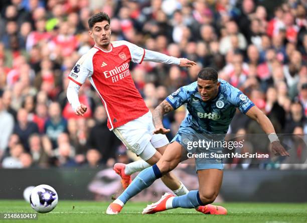 Kai Havertz of Arsenal is challenged by Diego Carlos of Aston Villa during the Premier League match between Arsenal FC and Aston Villa at Emirates...