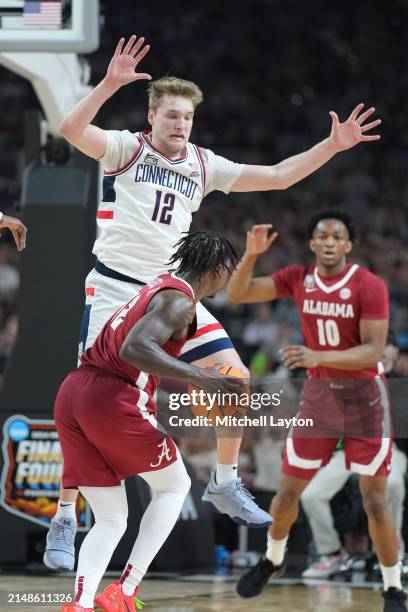 Cam Spencer of The Connecticut Huskies puts pressure on Latrell Wrightsell Jr. #12 of the Alabama Crimson Tide during the NCAA Mens Basketball...