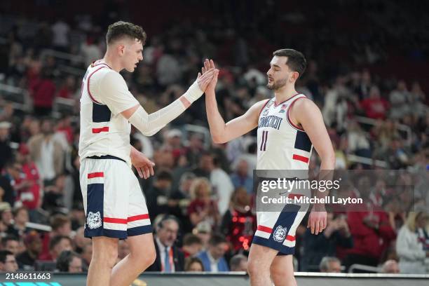 Donovan Clingan of The Connecticut Huskies congrats Alex Karaban coming out of the game during the NCAA Mens Basketball Tournament Final Four...