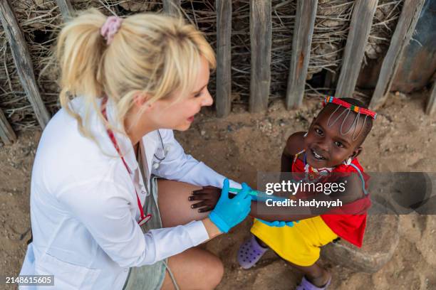 arzt macht eine injektion zu kleinen afrikanischen mädchen in einem kleinen dorf, kenia - ärzte ohne grenzen stock-fotos und bilder