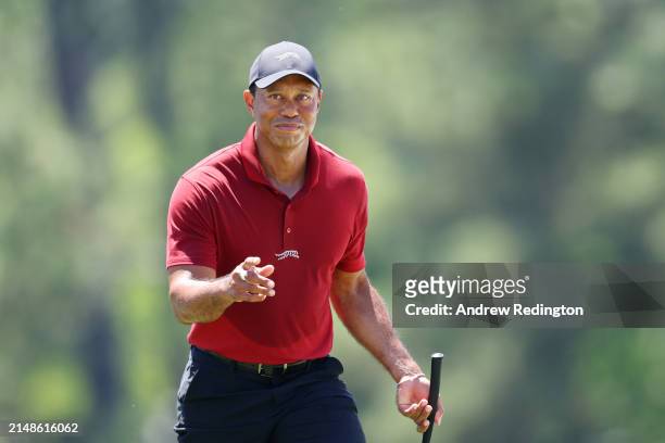 Tiger Woods of the United States acknowledges the crowd while walking to the 18th green during the final round of the 2024 Masters Tournament at...