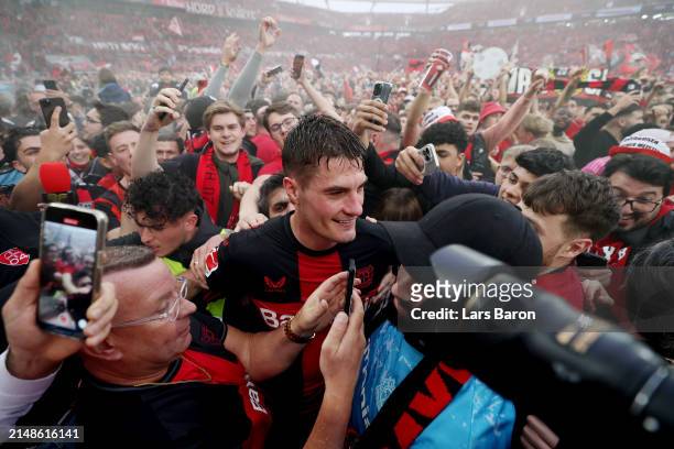 Patrik Schick of Bayer Leverkusen celebrates with fans who have invaded the pitch after the team's victory and winning the Bundesliga title for the...