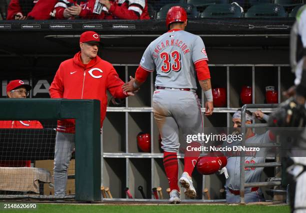 Christian Encarnacion-Strand of the Cincinnati Reds is congratulated by manager David Bell of the Cincinnati Reds after he scored against the Chicago...