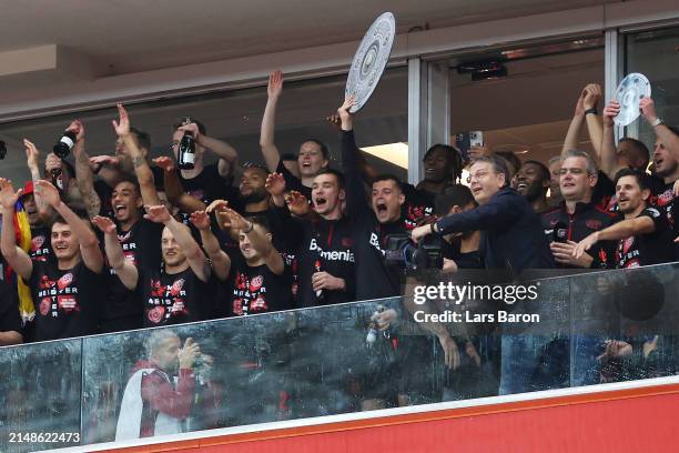 Granit Xhaka of Bayer Leverkusen celebrates with a replica trophy alongside players after their team's victory and winning the Bundesliga title for...