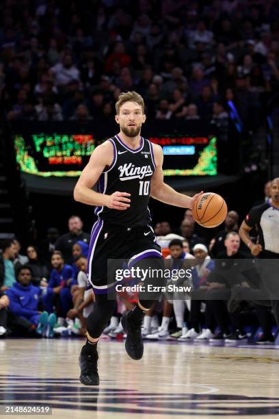 Domantas Sabonis of the Sacramento Kings dribbles the ball against the LA Clippers at Golden 1 Center on April 02, 2024 in Sacramento, California....