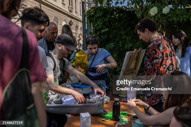 People hand over second hand objects while taking part in a swap event organized by the NPO Stooping Milano at Cascina Cuccagna on April 14, 2024 in...