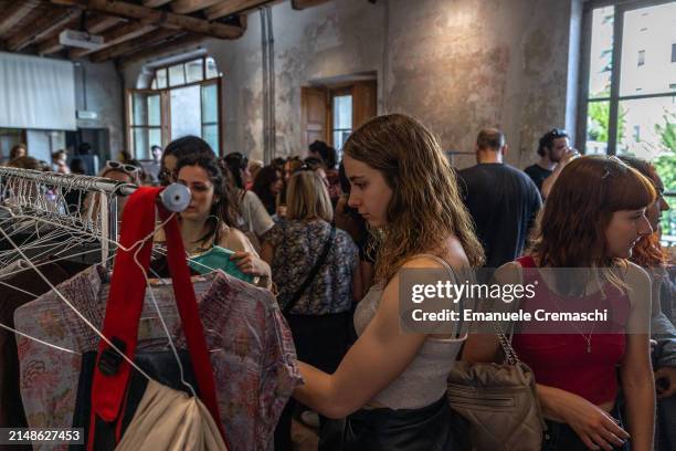 Young woman looks at some second hand garments as she takes part in a clothing swap event organized by the NPO Humana People to People at Cascina...