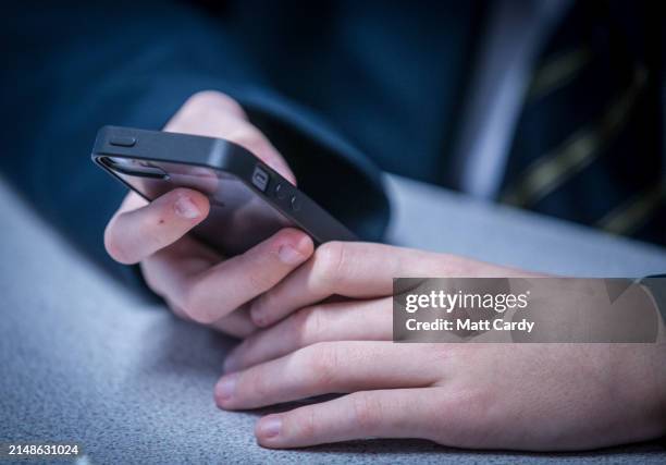 Year-old school boy looks at a iPhone screen on February 26, 2015 in Bristol, England. The amount of time children spend on screens each day rocketed...